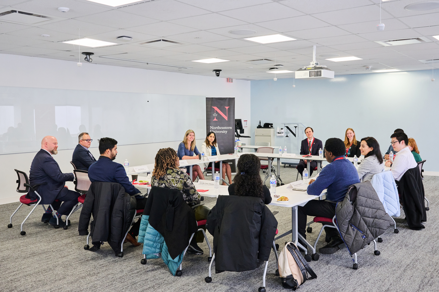 jill dunlop sitting at a conference table with a group of people