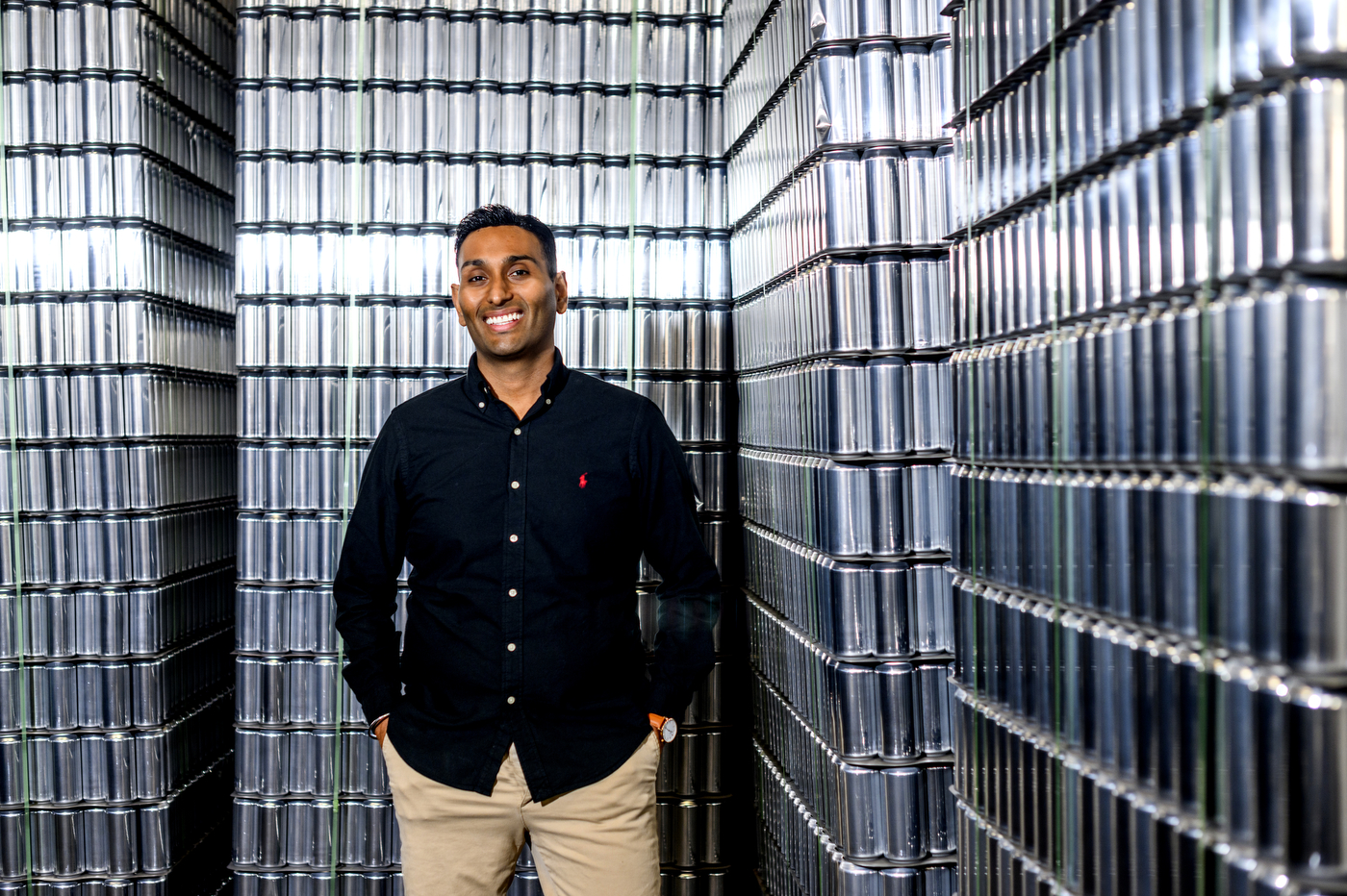 Vanit Sharma posing in front of shelves of beer