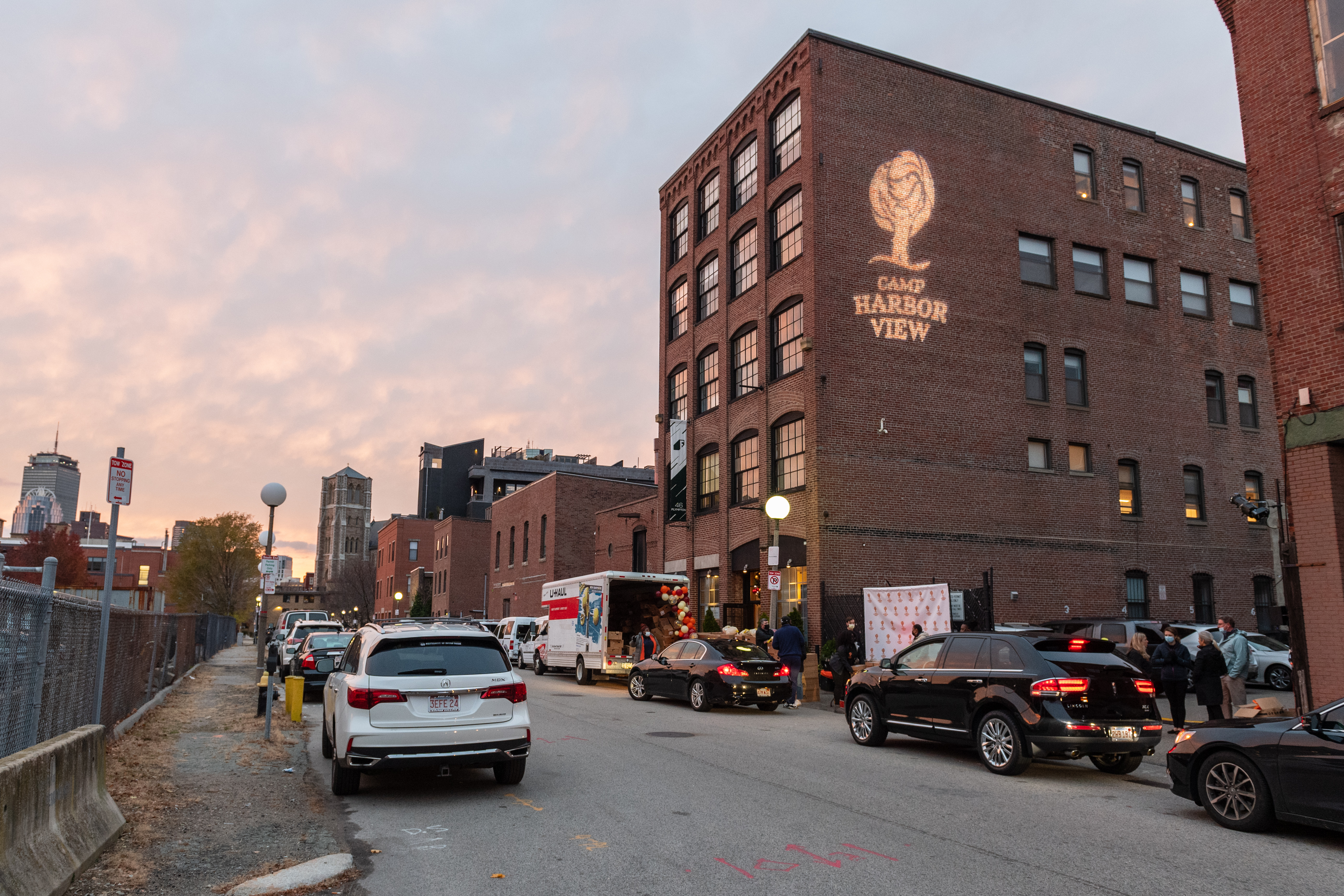 A brick building in Boston with the Camp Harbor View logo projected onto it