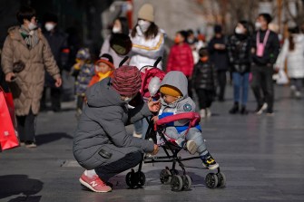 woman feeding a child in a stroller