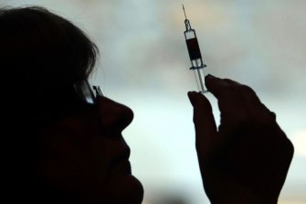 silhouette of a nurse holding up a syringe