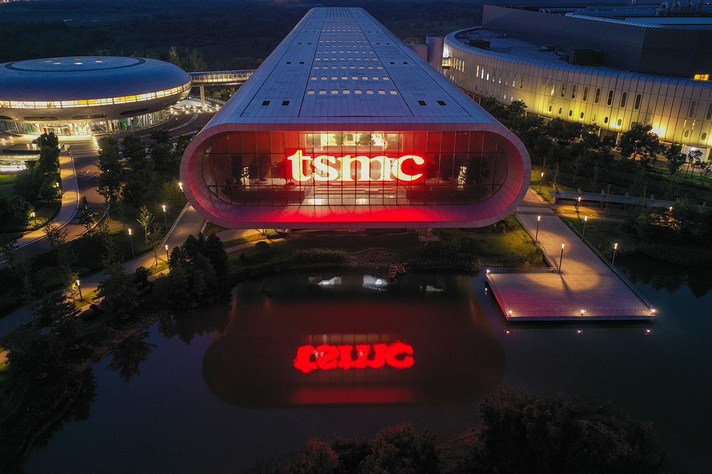 A wide, short building with the letters 'TSMC' lit up inside