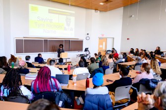 group of people gathered in a room listening to a speaker