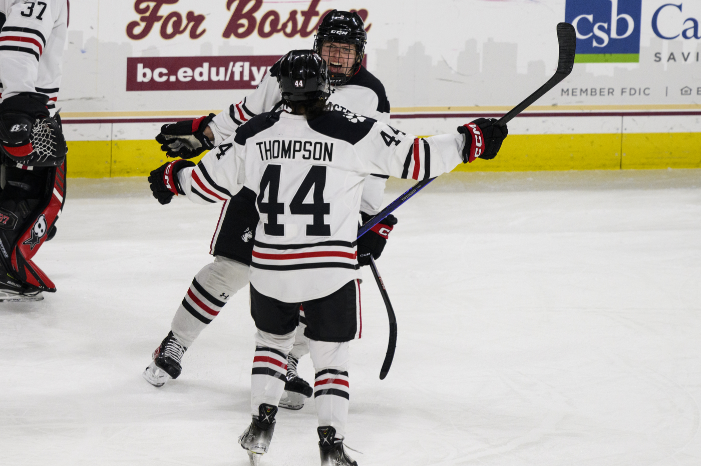 two hockey players skate towards each other to embrace