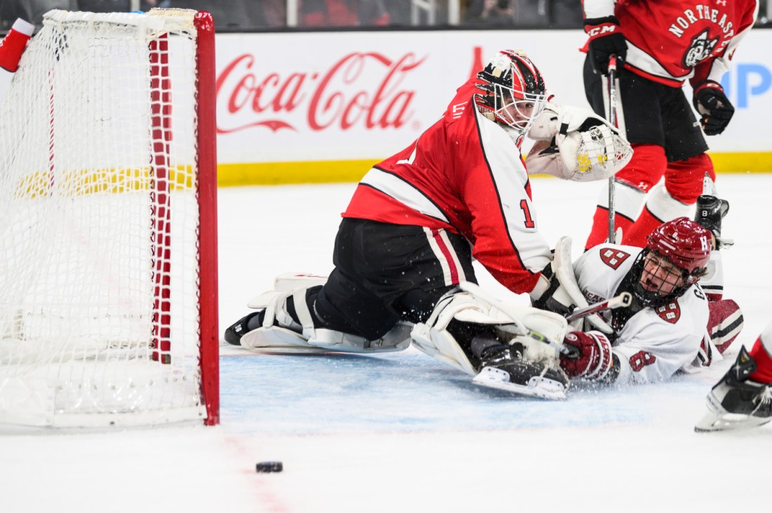 Northeastern men's hockey goalkeeper saving a shot. 