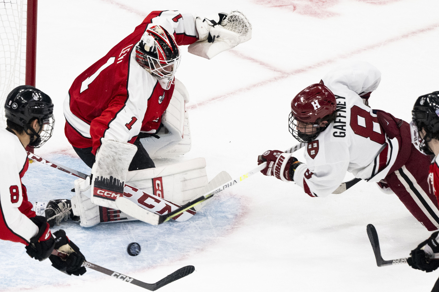 harvard hockey player shooting on northeasterns net