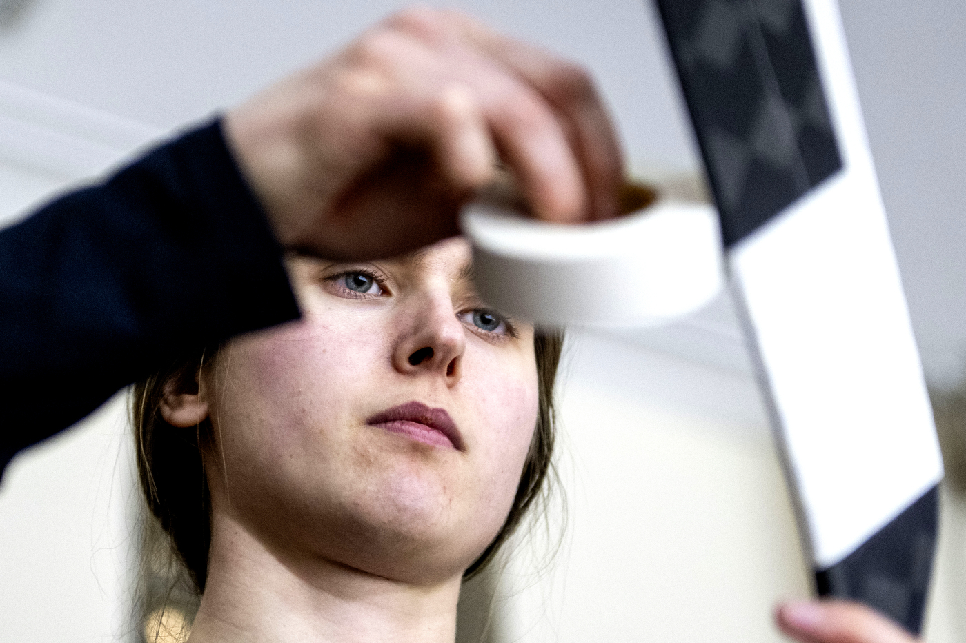 A Northeastern women's hockey player wraps a hockey stick with tape