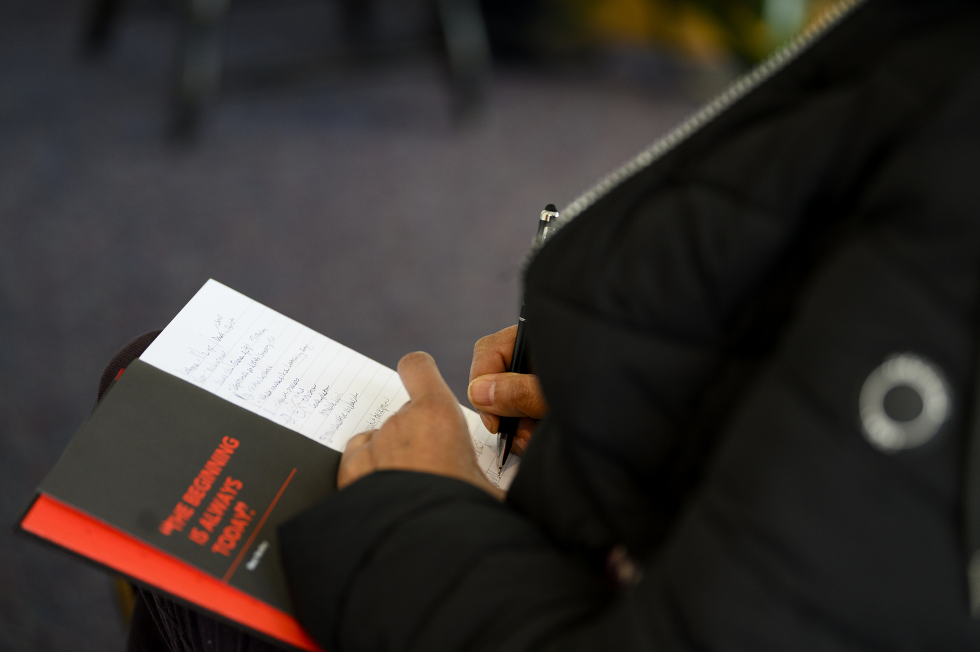 person taking notes at the fireside chat