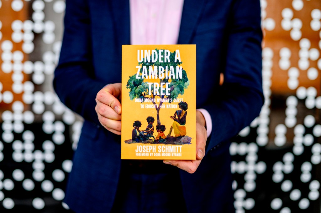 Joseph Schmitt holding a copy of Under a Zambian Tree