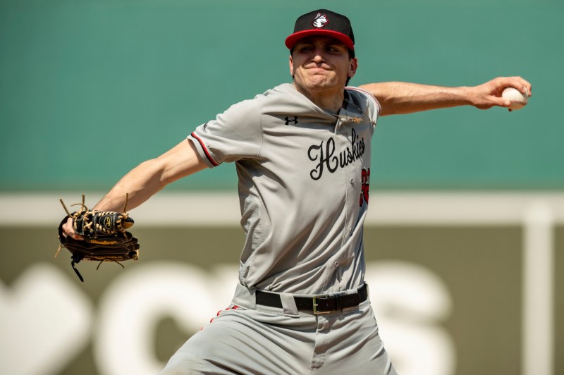 A Northeastern pitcher winds up to throw the ball