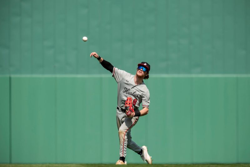 A Northeastern baseball player throws a ball