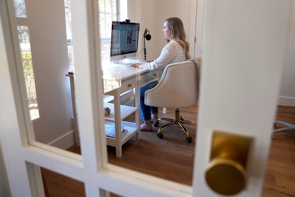 A person sits at a desk looking at a computer screen