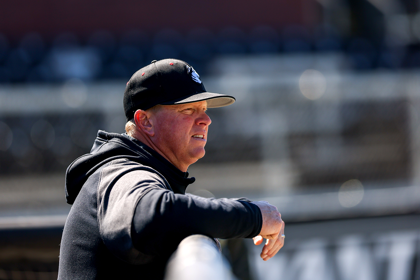 Mike Glavine leaning on fence at baseball pitch