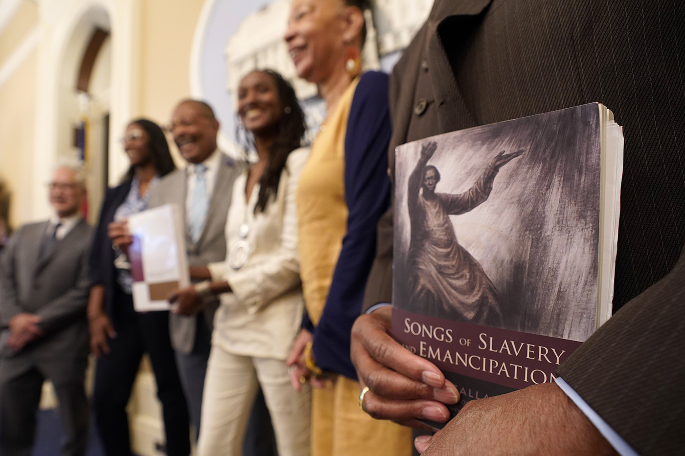 A person holds a copy of the book Songs of Slavery and Emancipation