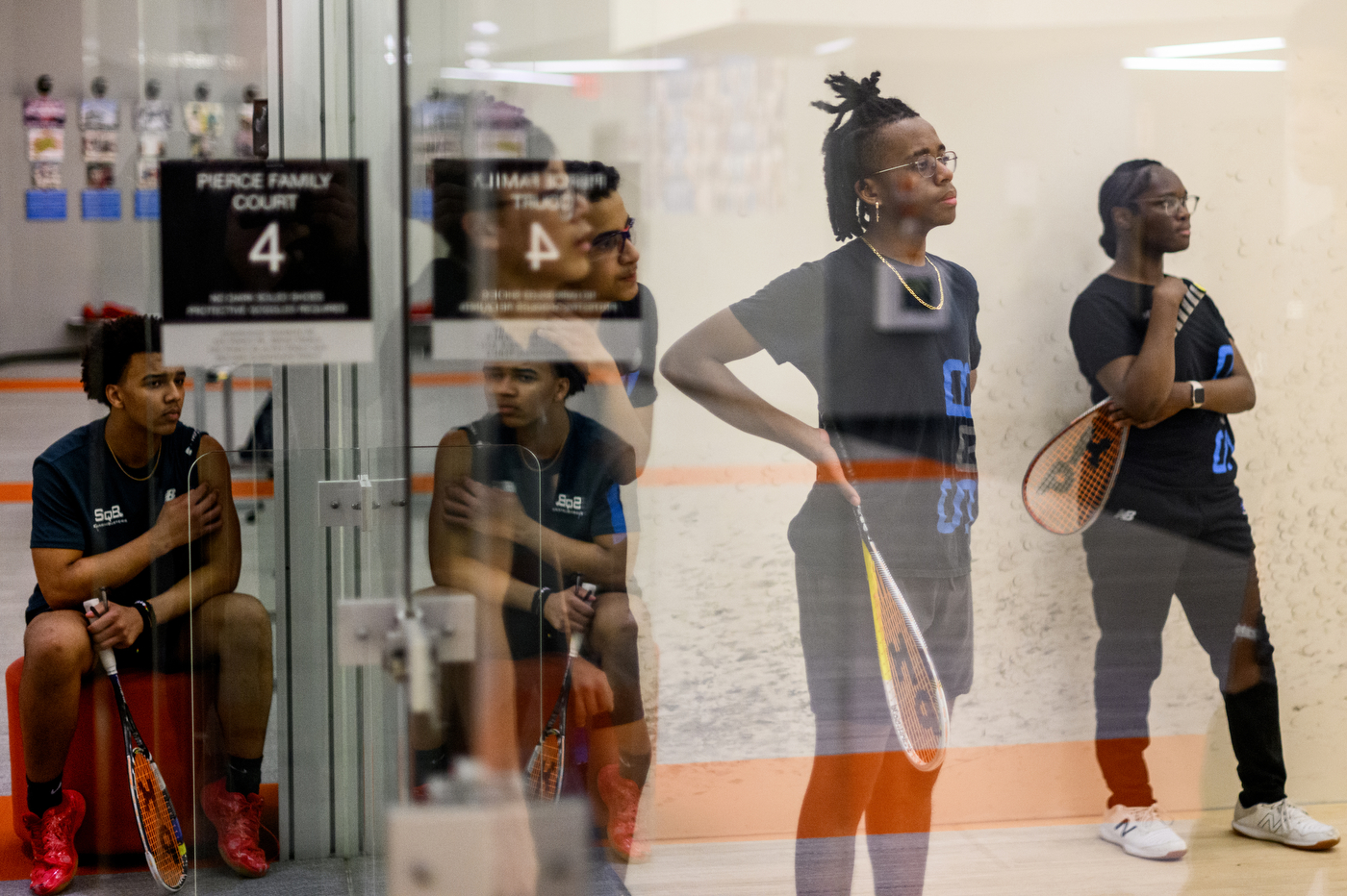 people standing inside squash courts in SquashBusters