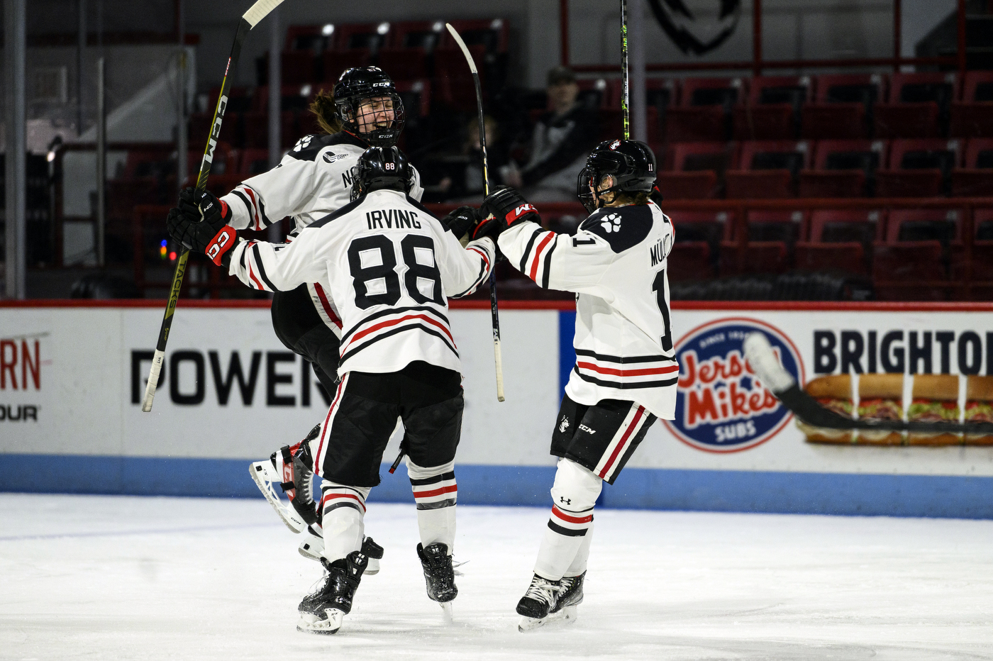 Three Northeastern players celebrate a goal