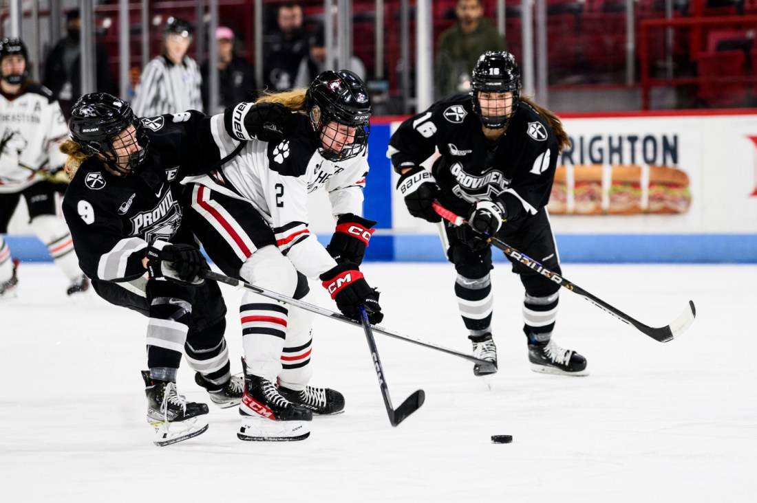 Opposing players chase a puck