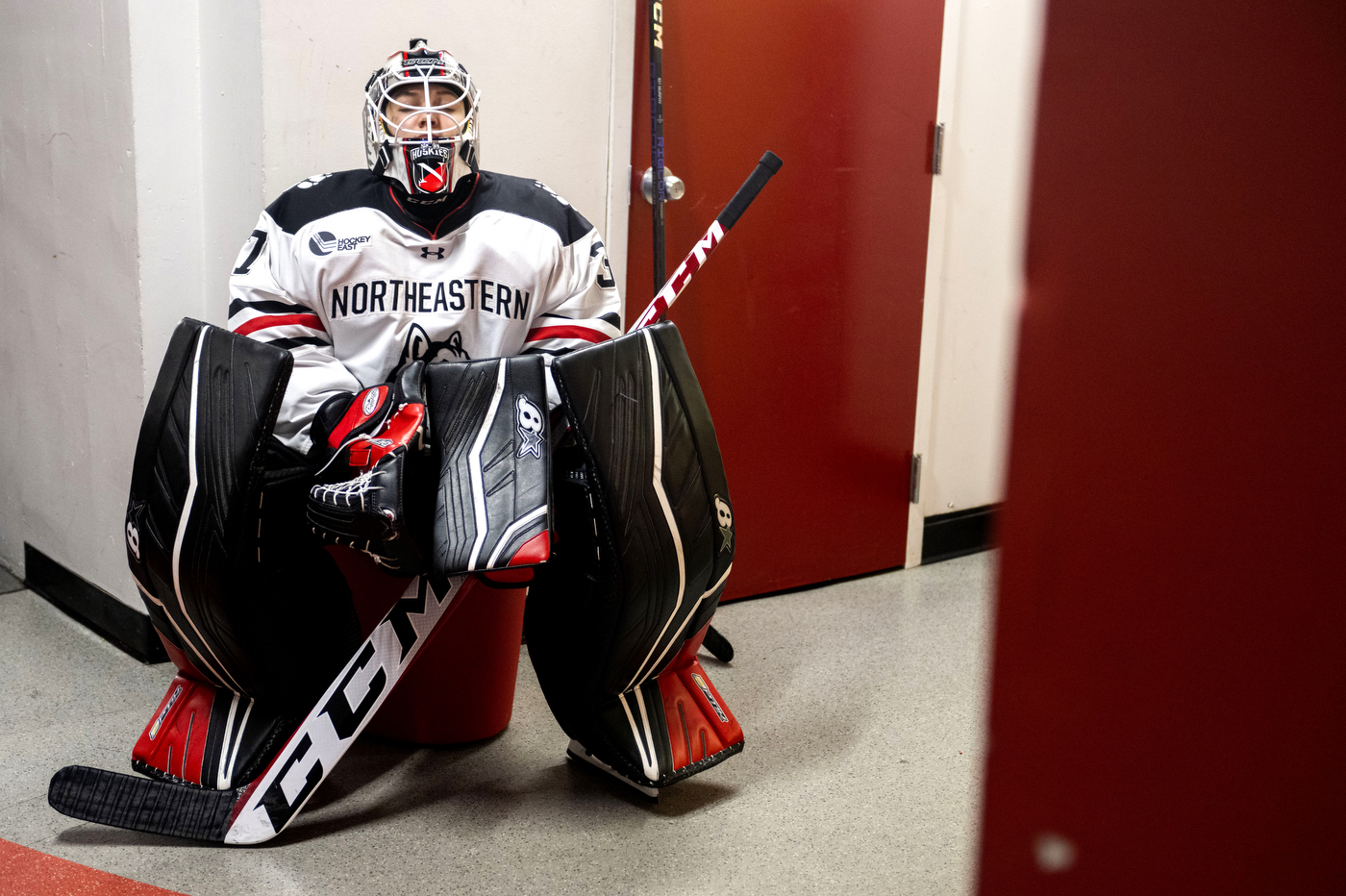 A goaltender waits in a hallway