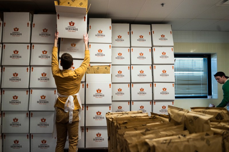 student stacking boxes of food at Community Servings in Jamaica Plain