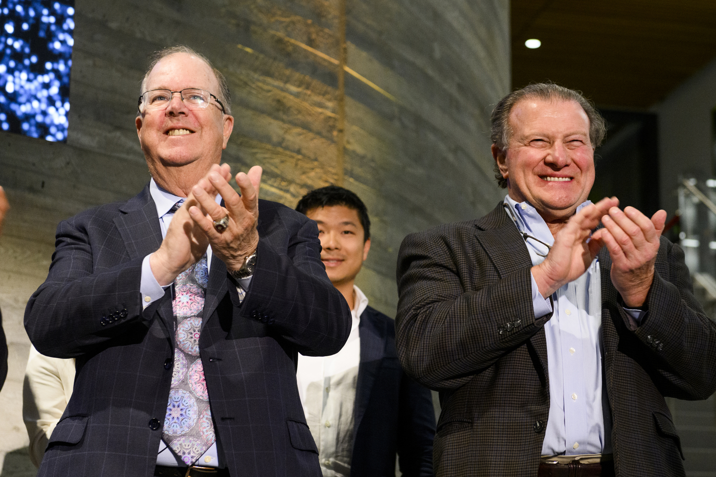 two people clapping at D'Amore McKim's 100th Anniversary event