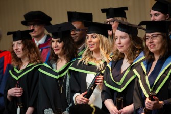 students wearing caps and gowns at masters graduation