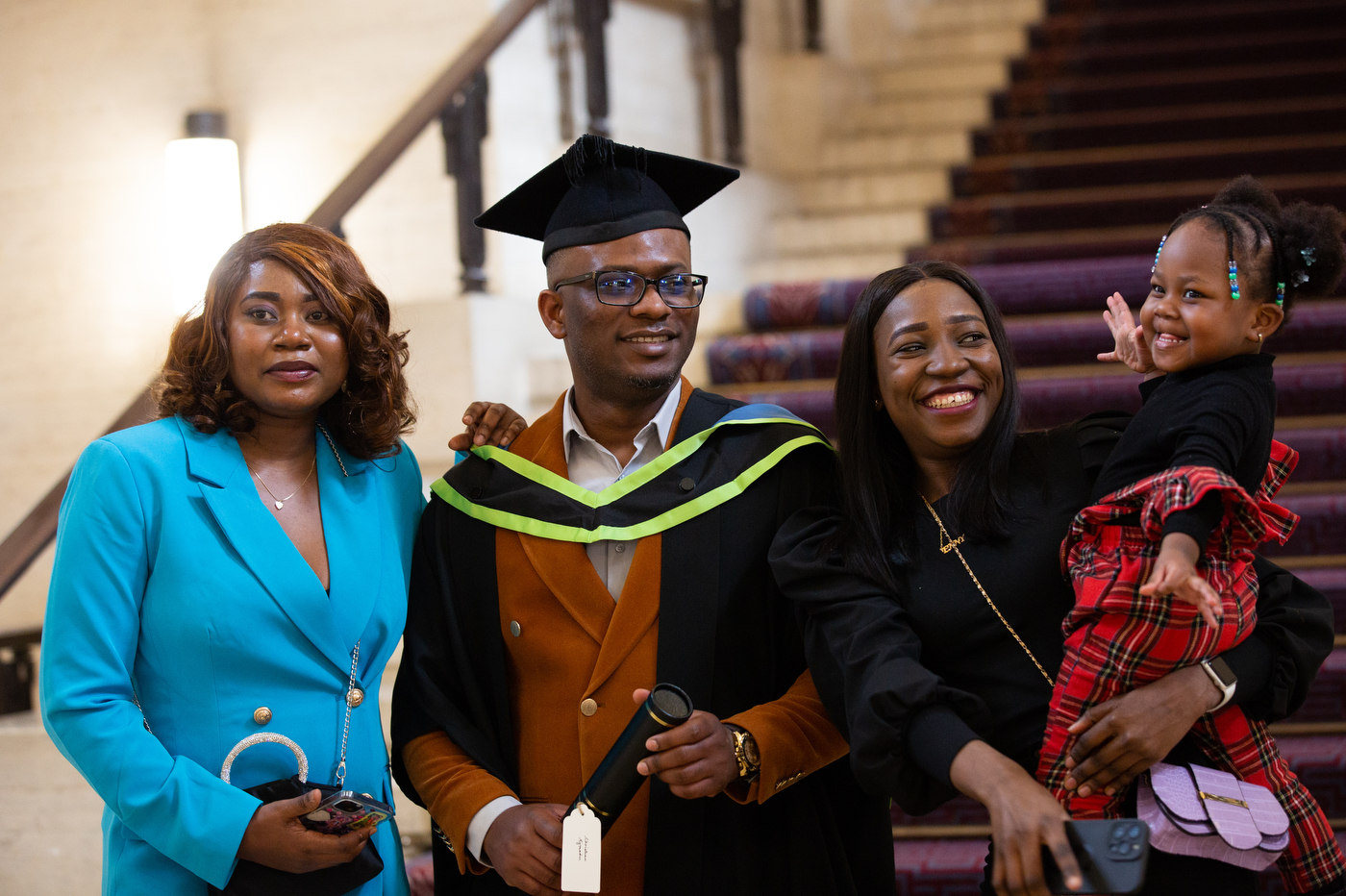 student posing with their family at graduation