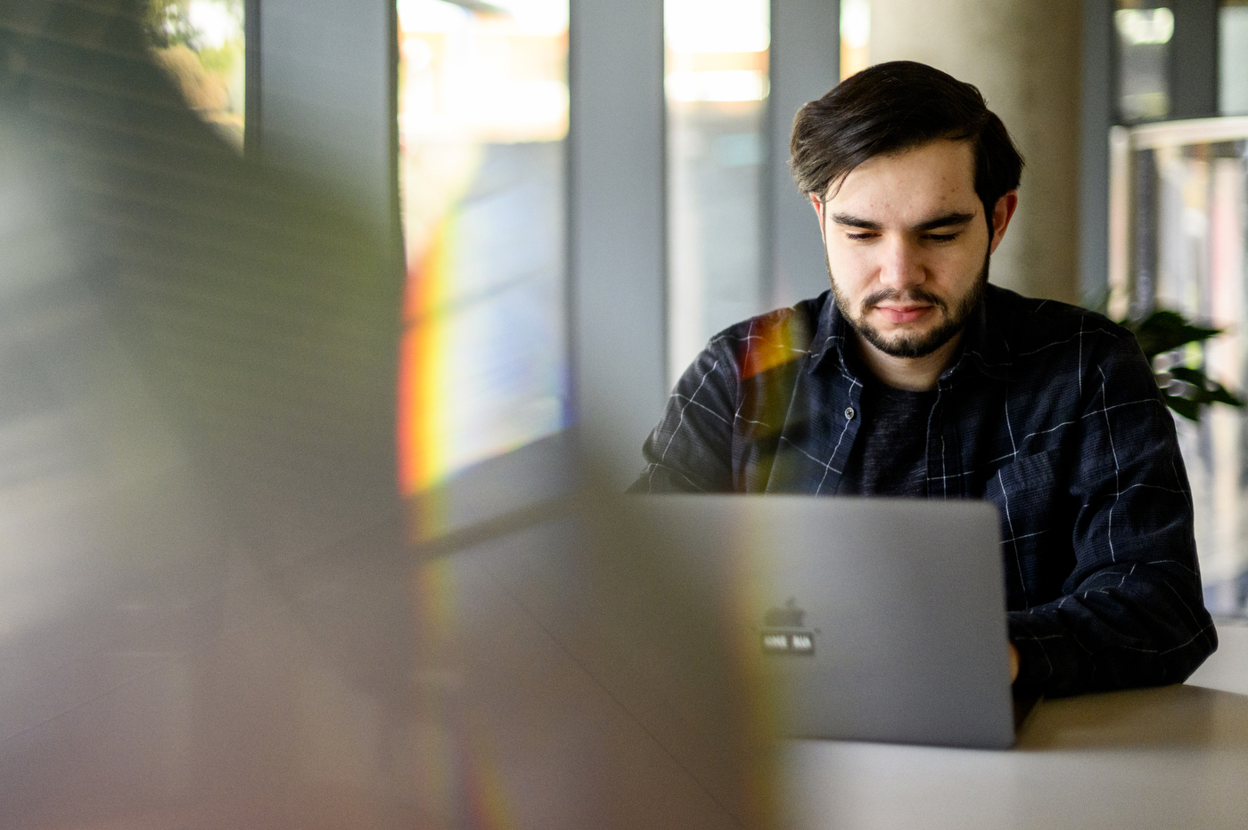 A man stares down at laptop computer screen