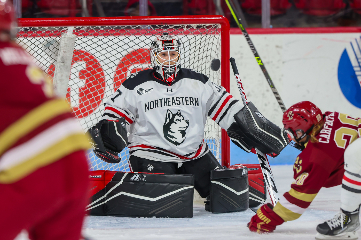 northeastern hockey goalkeeper saving a shot on net