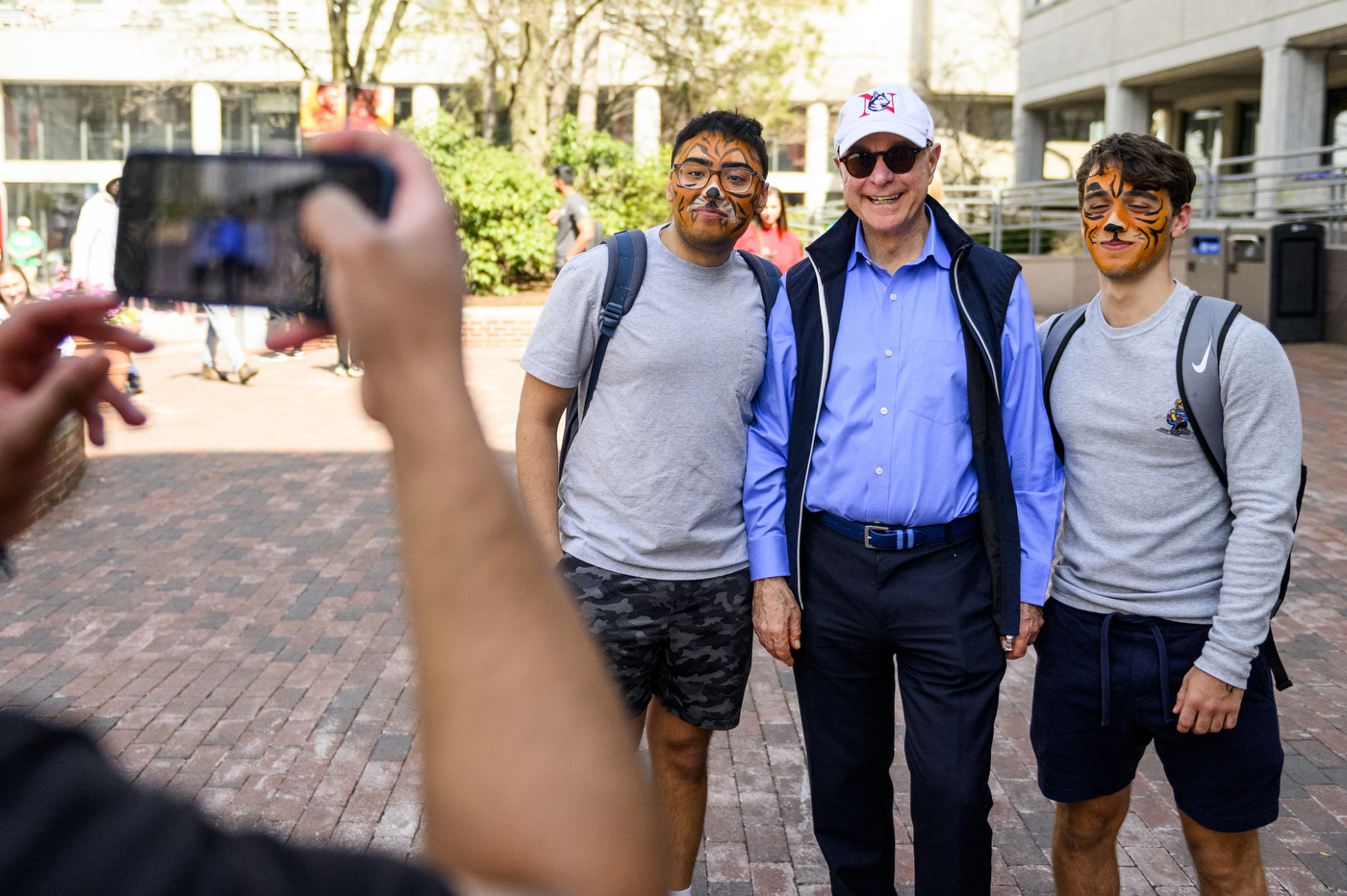 President Joseph Aoun posing with two students wearing face paint