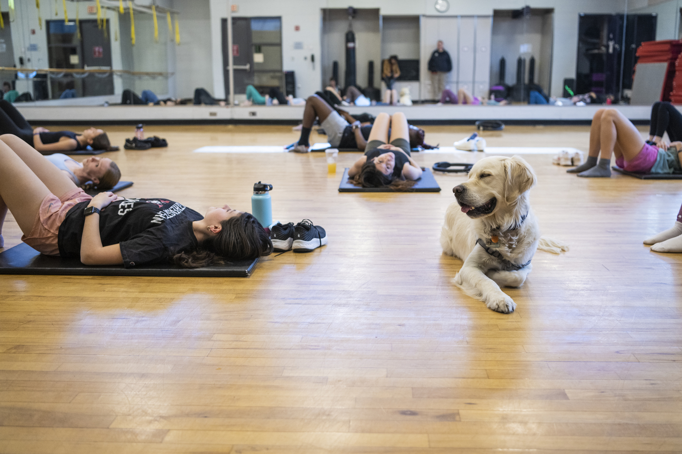 Cooper sitting amongst students doing pilates