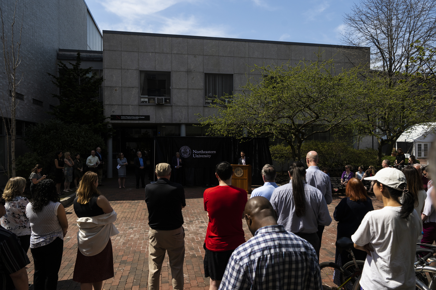 People look on as someone speaks from behind a podium