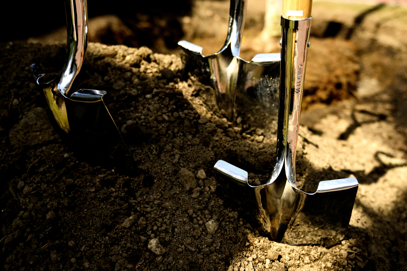 Three shovels stuck into dirt