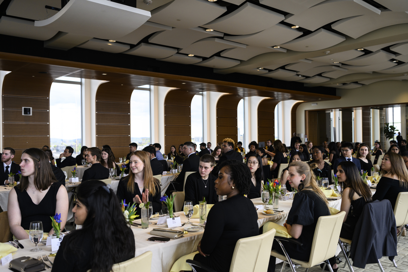 A crowded room full of people sitting at tables