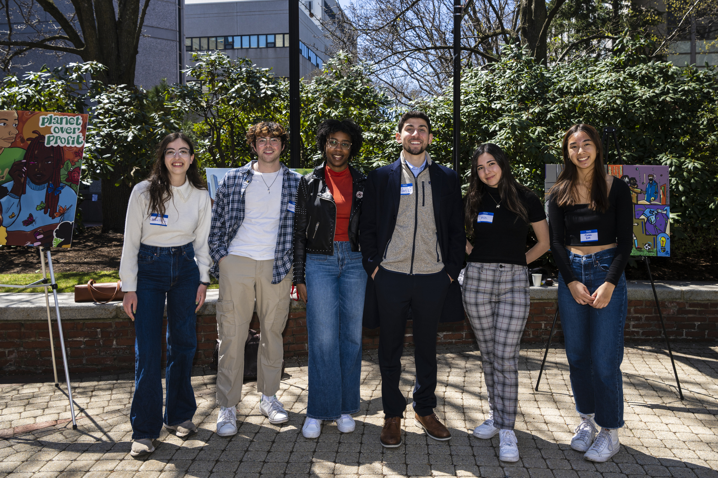 5 student winners of Climate Justice and Sustainability Hub competition posing in front of their murals outside