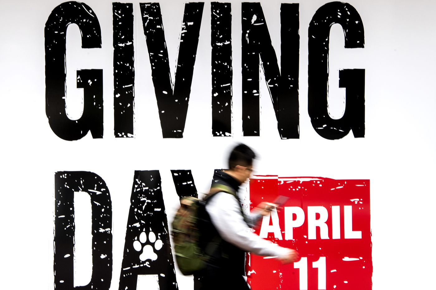 A student walks past a Giving Day sign outside the Curry Student Center.