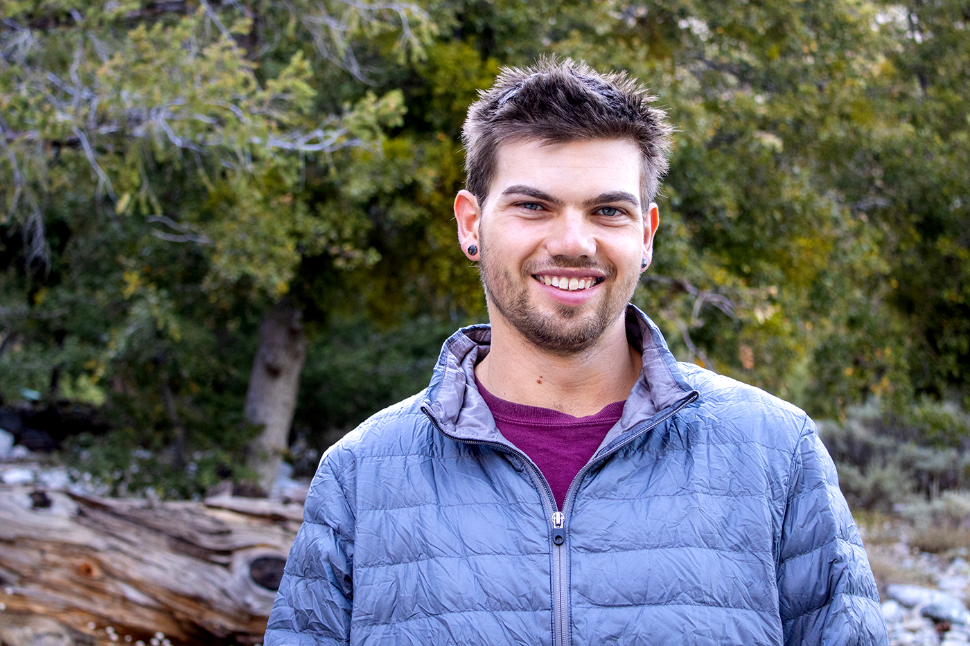 Michael Nelson stands outside in front of trees.