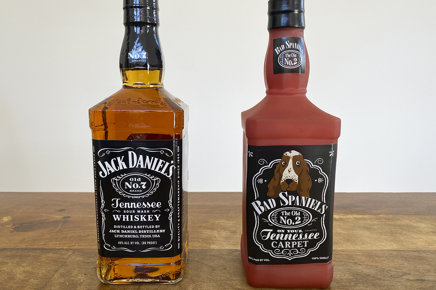 Jack Daniels bottle and Bad Spaniels dog toy side by side on a table