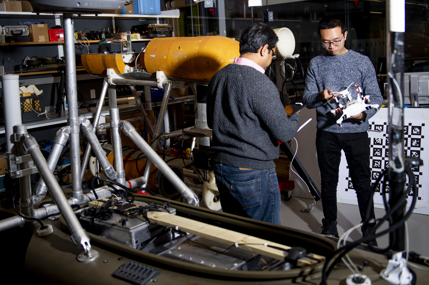 Two people work to measure how quickly icebergs are melting in a laboratory.