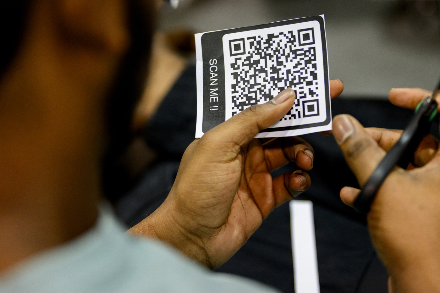 A graduate cutting out a QR code