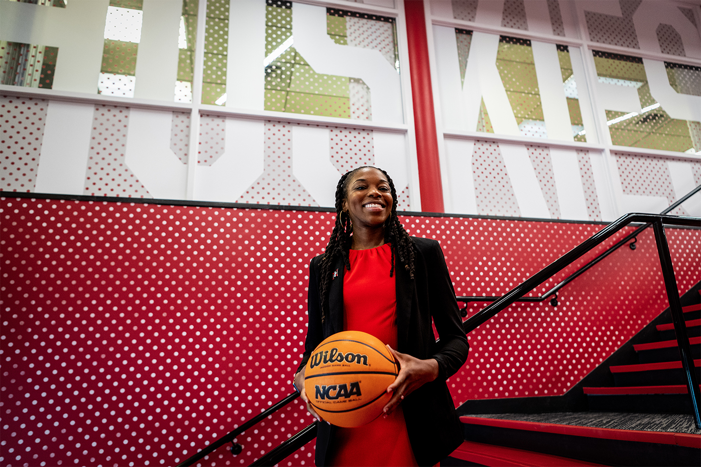 A smiling woman holds a basketball