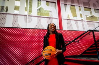 A smiling woman holds a basketball