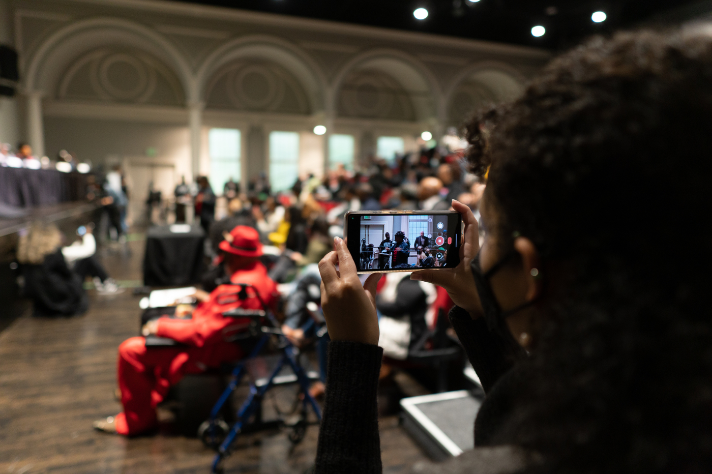 audience member taking a photo on their iPhone