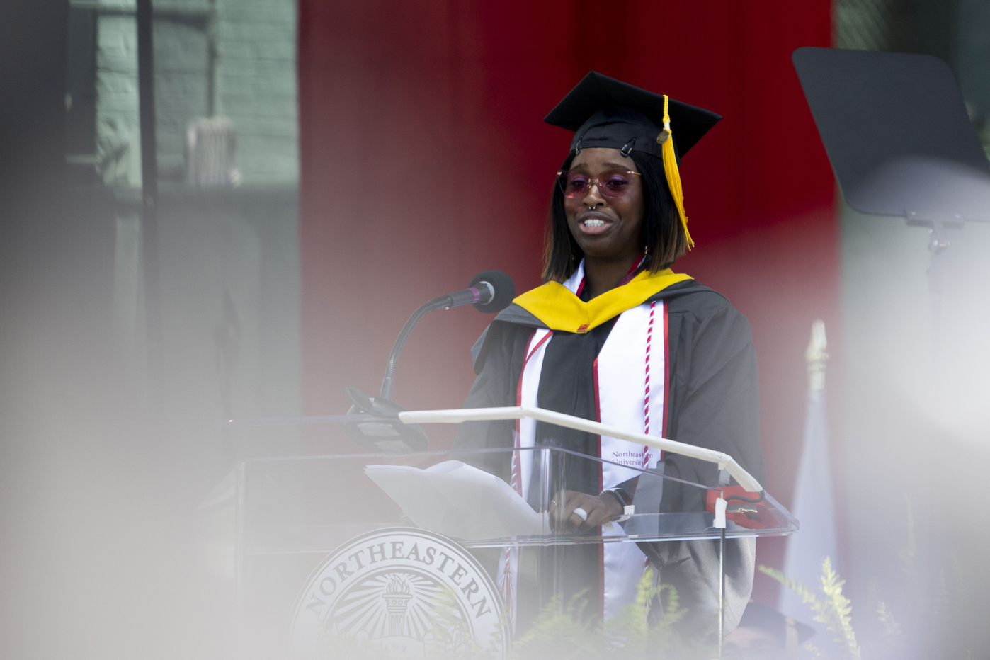 Kristine Umeh speaking at graduate commencement ceremony at Fenway