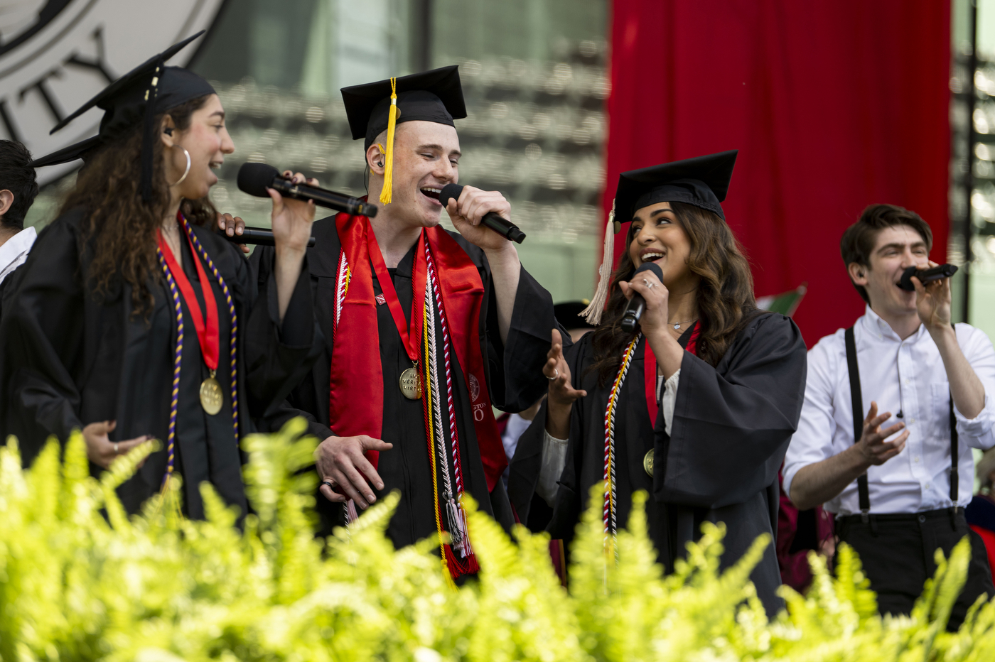 students singing in commencement regalia