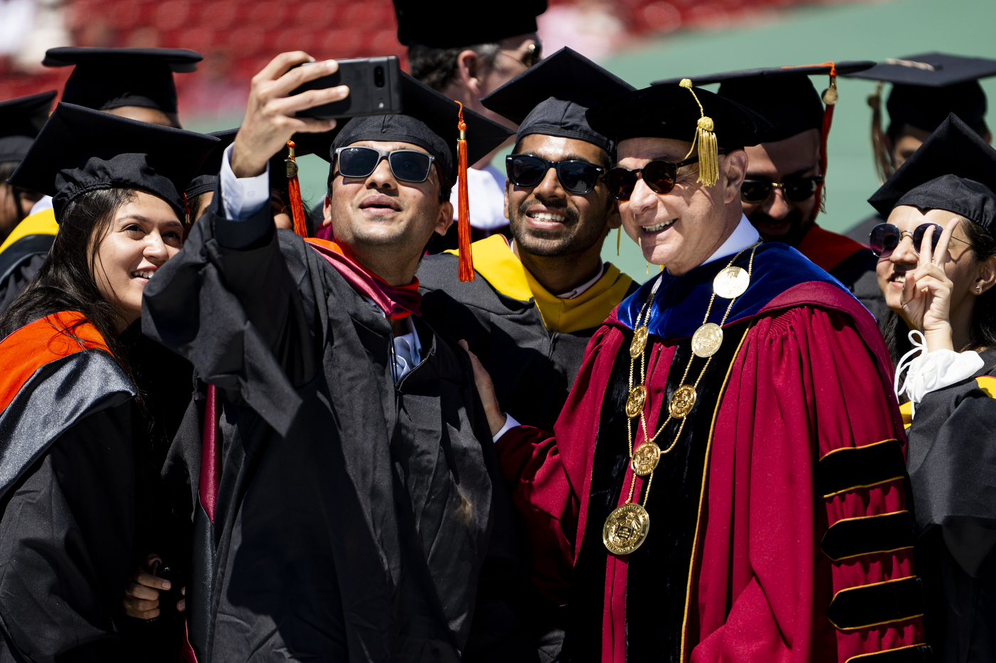 President Aoun taking a selfie with graduates.