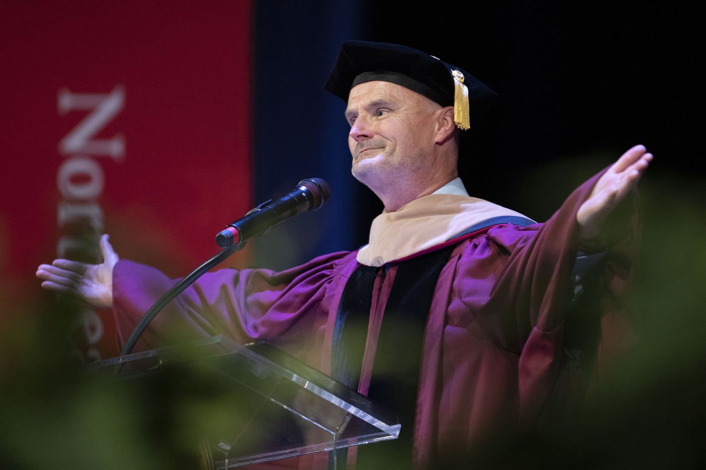 speaker at Vancouver convocation with arms spread wide