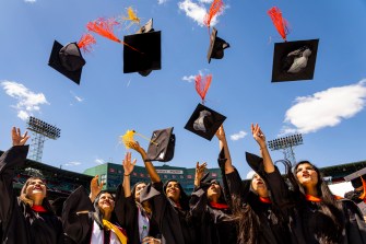 students throwing their graduation caps into the air