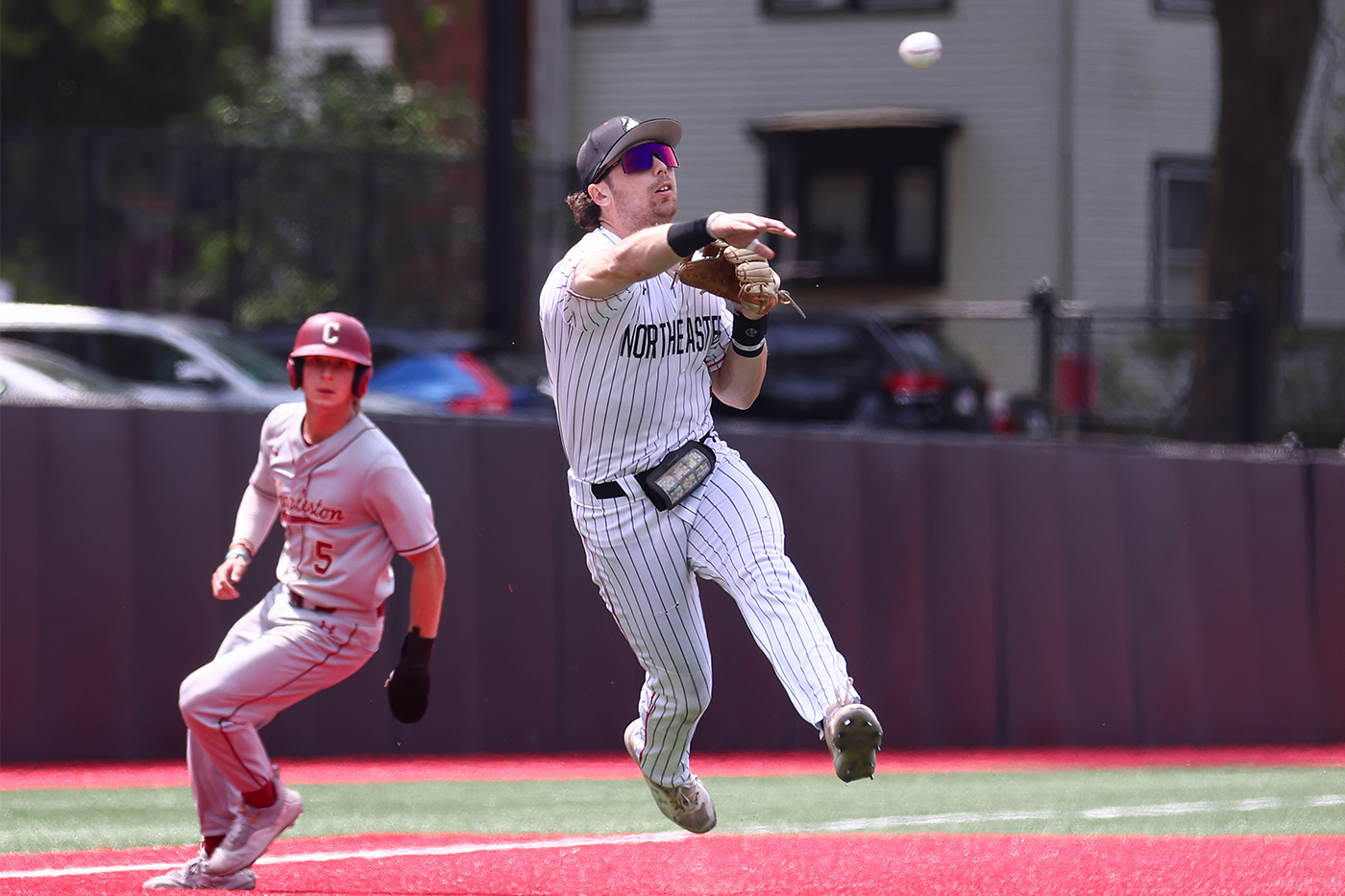 A third baseman throws the ball to first base.