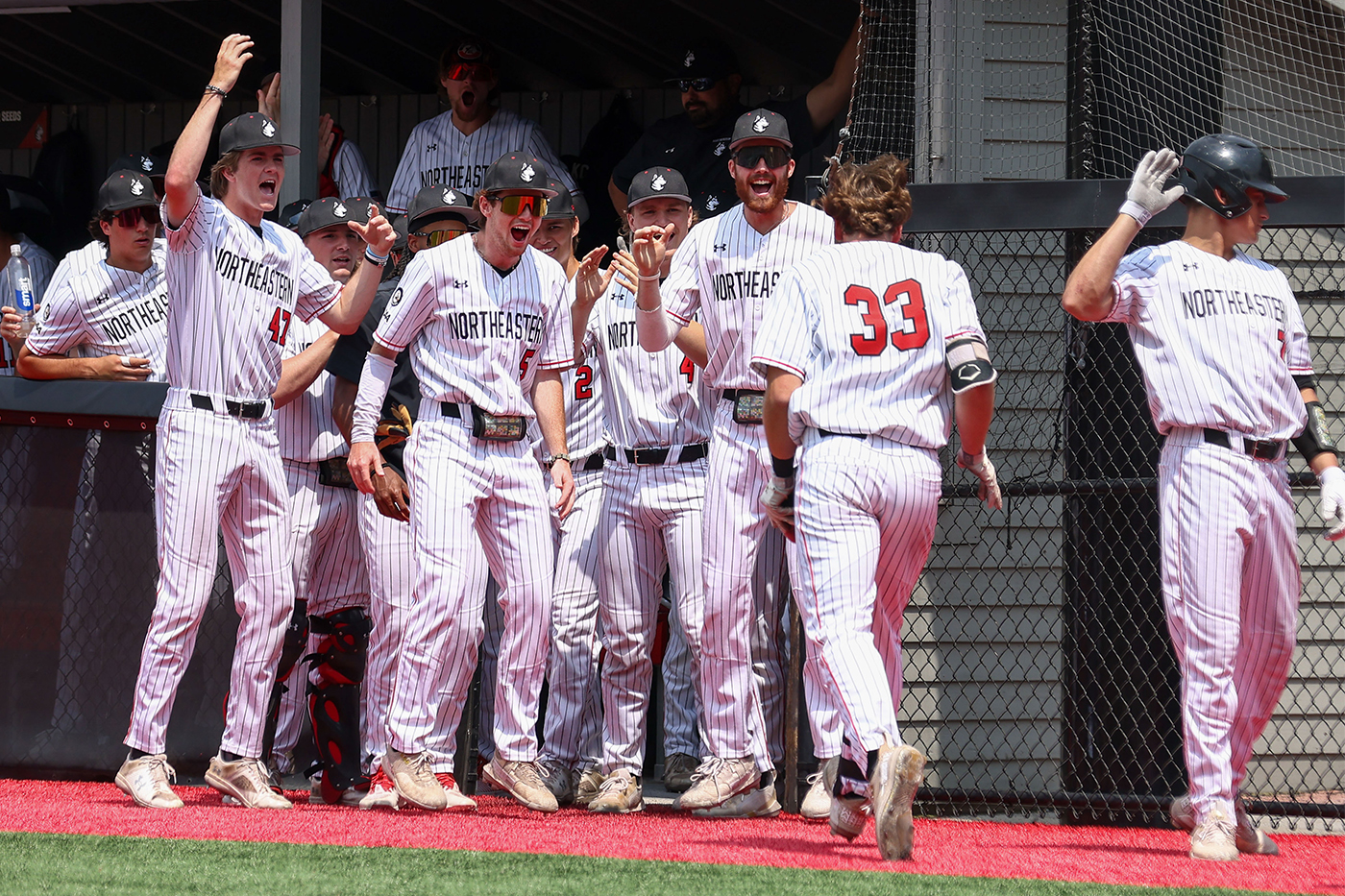 Baseball players gather at home plate to celebrate teammates' home run