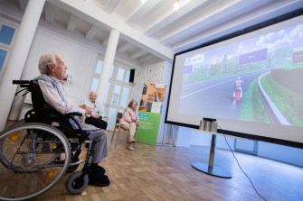 older person playing a video game on a monitor